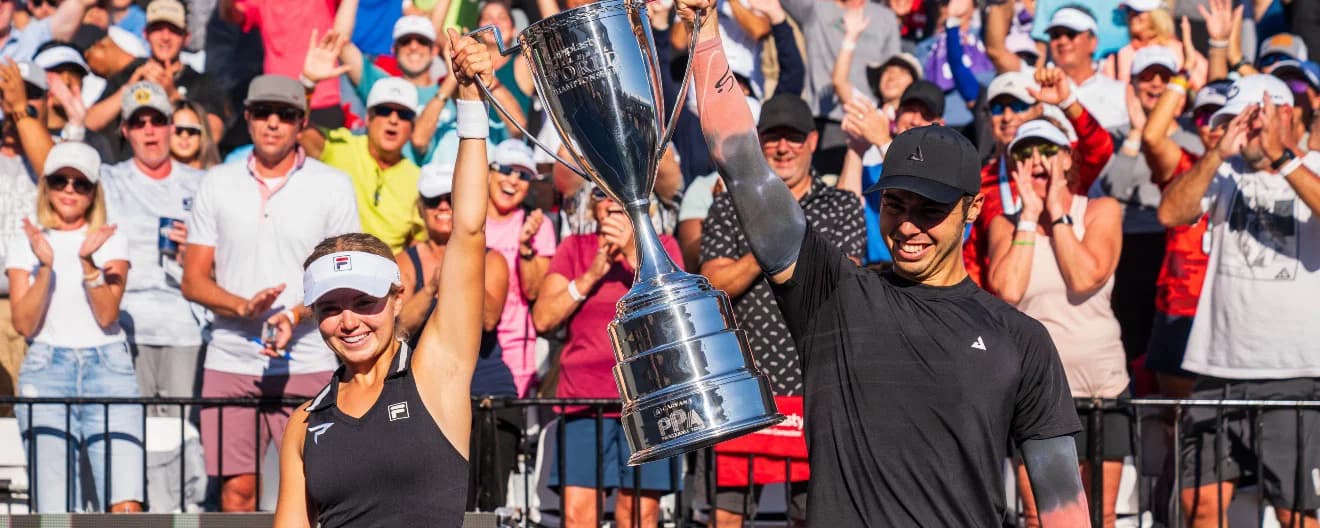 Anna Leigh Waters and Ben Johns holding up a trophy
